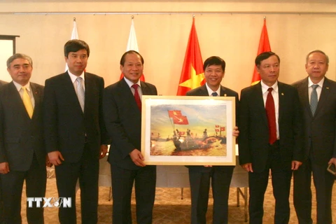 Bộ trưởng Bộ Thông tin và Truyền thông Trương Minh Tuấn tặng tượng trưng một bức ảnh cho Đại sứ quán Việt Nam tại Nhật Bản. (Ảnh: Nguyễn Tuyến/TTXVN)
