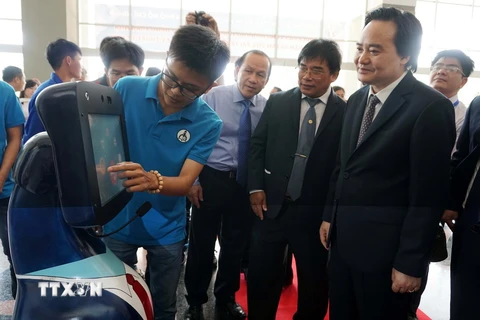 Bộ trưởng Bộ Giáo dục và Đào tạo Phùng Xuân Nhạ tham quan sản phẩm robot tiếp tân do sinh viên trường Đại học Sư phạm Kỹ thuật Thành phố Hồ Chí Minh chế tạo. (Ảnh: Phương Vy/TTXVN)