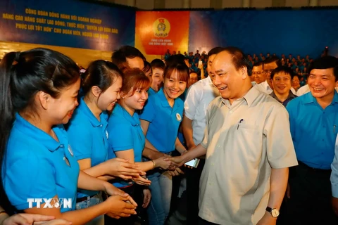 Thủ tướng Chính phủ Nguyễn Xuân Phúc gặp mặt công nhân lao động vùng kinh tế trọng điểm Miền Trung nhân ngày Quốc tế lao động 1/5. (Ảnh: Thống Nhất/TTXVN)