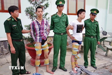 Hai đối tượng Nguyễn Tùng Ánh và Phạm Văn Thuận cùng tang vật bị bắt giữ tại Đồn Biên phòng cửa khẩu quốc tế Mộc Bài. (Ảnh: Lê Đức Hoảnh/TTXVN)