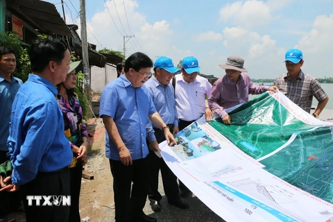 Phó Thủ tướng Chính phủ Trịnh Đình Dũng trực tiếp khảo sát tại điểm sạt lở. (Ảnh: Công Mạo/TTXVN)