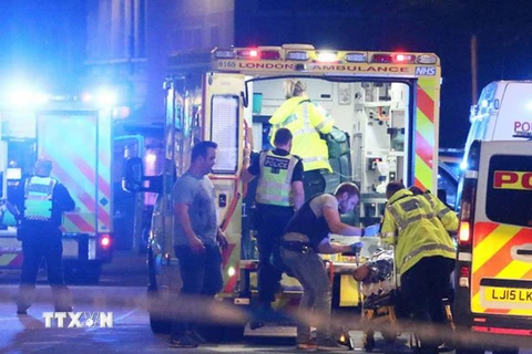 Sơ cứu nạn nhân tại hiện trường vụ xe tải lao vào đám đông trên Cầu London, Anh tối 3/6. (Nguồn: AP/TTXVN)