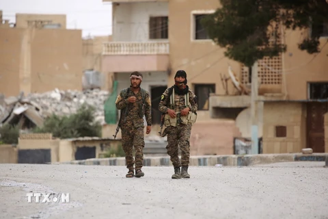 Lực lượng Dân chủ Syria, liên minh giữa người Kurd và các chiến binh Arab được Mỹ hậu thuẫn, tuần tra tại thị trấn Tabqa, cách Raqa 55 km về phía tây ngày 18/5. (Nguồn: AFP/TTXVN)