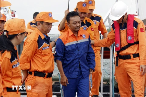 Thuyền viên Suhaimi Bin Muhamad được đội cứu hộ đưa vào bờ an toàn. (Ảnh: Đoàn Mạnh Dương/TTXVN)