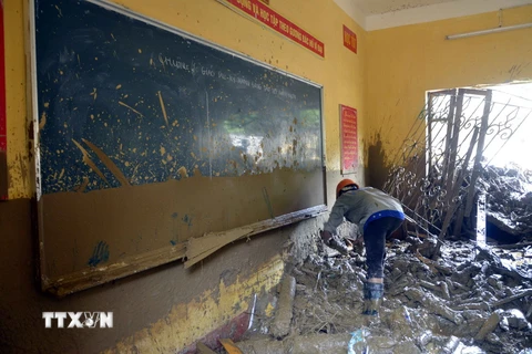 Lực lượng chức năng thu dọn những đồ vật còn sót lại tại một trường học ở thị trấn Mù Cang Chải. (Ảnh: Tuấn Anh/TTXVN)