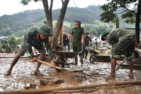 Các chiến sỹ tham gia dọn dẹp bùn đất tại trường học ở Mù Cang Chải. (Ảnh: Đinh Hữu Dư/TTXVN)
