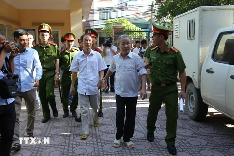 Dẫn giải bị cáo Bạch Văn Đông và Nguyễn Tiến Triển vào phòng xét xử. (Ảnh: Nguyễn Văn Cảnh/TTXVN)