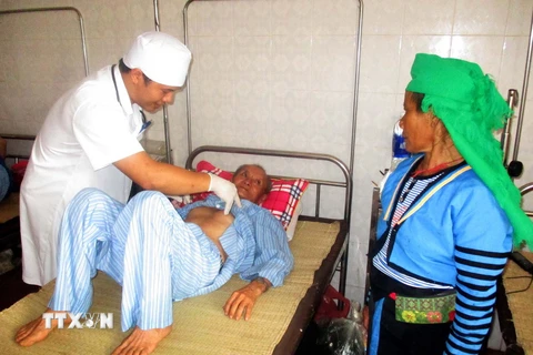 Bác sỹ Bệnh viện Đa khoa huyện Mường Lát khám cho bệnh nhân đến từ tỉnh Huaphanh. (Ảnh: Nguyễn Nam/TTXVN)