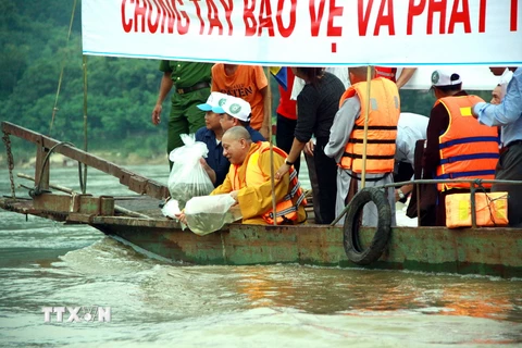Các đại biểu thả cá tái tạo nguồn lợi thủy sản trên sông Lô. (Ảnh: Quang Cường/TTXVN)
