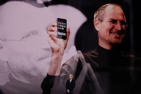 Hình ảnh Steve Job cùng chiếc iPhone đầu tiên trên sân khấu hội trường Steve Jobs Theater. (Nguồn: Getty)
