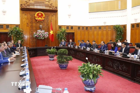 Thủ tướng Nguyễn Xuân Phúc tiếp Nhóm các nhà đầu tư quốc tế do ông Nirukt Sapru, Tổng Giám đốc Ngân hàng Standard Chartered tại Việt Nam dẫn đầu. (Ảnh: Văn Điệp/TTXVN)