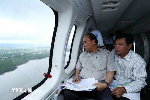 Thủ tướng Nguyễn Xuân Phúc đi thị sát các khu vực bị ảnh hưởng và tác động bởi biến đổi khí hậu thuộc vùng Đồng bằng sông Cửu Long. (Ảnh: Thống Nhất/TTXVN)