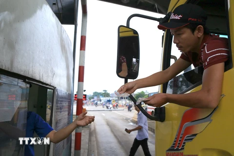Lái xe dùng tiền mệnh giá 200 - 500 đồng mua vé qua trạm thu phí BOT tuyến tránh Biên Hòa gây ùn tắc kéo dài, ngày 2/10. (Ảnh: Sỹ Tuyên/TTXVN)