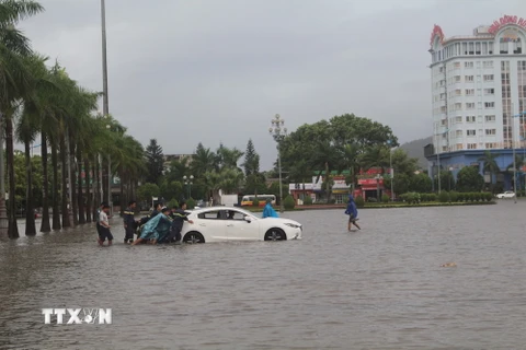 Cứu hộ xe ôtô bị chết máy do ngập nước ở thành phố Thanh Hóa, tỉnh Thanh Hóa. (Ảnh: Hoa Mai/TTXVN)