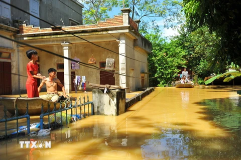 Nước ngập sâu nên người dân tại thôn Kiến Phong, xã Gia Tường, huyện Nho Quan phải di chuyển bằng thuyền. (Ảnh: Minh Đức/TTXVN)