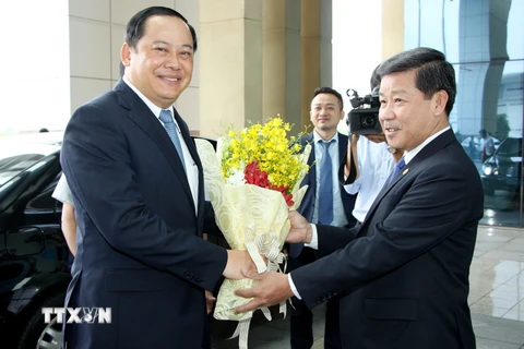 Chủ tịch tỉnh Bình Dương Trần Thanh Liêm (phải) tặng hoa chúc mừng Phó Thủ tướng Lào Sonexay Siphandone. (Ảnh: Nguyễn Văn Việt/TTXVN)