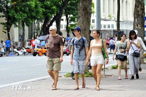 Khách du lịch nước ngoài trên phố đi bộ hồ Hoàn Kiếm. (Ảnh: Quang Quyết/TTXVN)