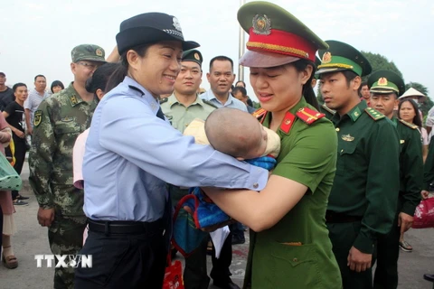 Công an thành phố Móng Cái (Quảng Ninh) phối hợp với Đồn Biên phòng Cửa khẩu Quốc tế Móng Cái tiếp nhận một trẻ em bị bán sang Trung Quốc. (Ảnh: Nguyễn Hoàng/TTXVN)