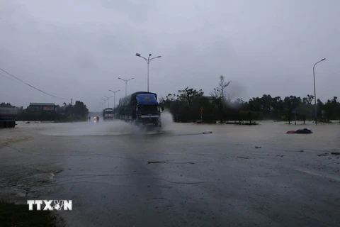 Nước lụt dâng ngập Quốc lộ 1A tại km808, thuộc địa phượng thị xã Hương Trà. (Ảnh: Hồ Cầu/TTXVN)