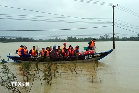 Lực lượng Công an tỉnh Quảng Nam giúp dân di chuyển ra khỏi vùng ngập lụt tại xã Tam Đàn, huyện Phú Ninh, Quảng Nam. (Ảnh: Nguyễn Sơn/TTXVN)