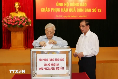 Tổng Bí thư Nguyễn Phú Trọng và nguyên Tổng Bí thư Nông Đức Mạnh tham gia quyên góp ủng hộ đồng bào khắc phục hậu quả thiên tai. (Ảnh: Trí Dũng/TTXVN)