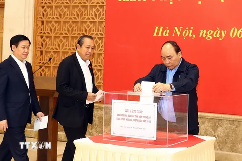 Thủ tướng Nguyễn Xuân Phúc và các Phó Thủ tướng quyên góp ủng hộ đồng bào các tỉnh Nam Trung Bộ khắc phục hậu quả thiệt hại do bão số 12. (Ảnh: Thống Nhất/TTXVN)