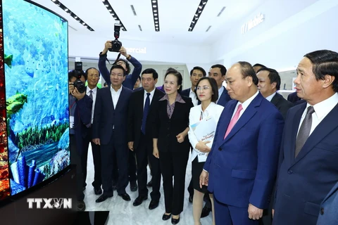 Thủ tướng Nguyễn Xuân Phúc xem các sản phẩm của Công ty LG Display Việt Nam Hải Phòng. (Ảnh: Thống Nhất/TTXVN)