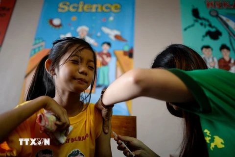 Tiêm vắcxin phòng bệnh sốt xuất huyết cho học sinh trường tiểu học Parang ở Marikina, phía tây Manila ngày 4/4. (Nguồn: AFP/TTXVN)