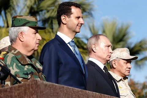 Tổng thống Syria Bashar al-Assad đứng bên cạnh Tổng thống Nga Putin, ngày 11/12 ở căn cứ không quân Nga tại Hmeimim, Syria. (Nguồn: AFP)