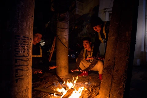 Để xua tan cái rét, nhiều người lao động đã tìm cách đốt lửa trong đêm. (Ảnh: Minh Sơn/Vietnam+)
