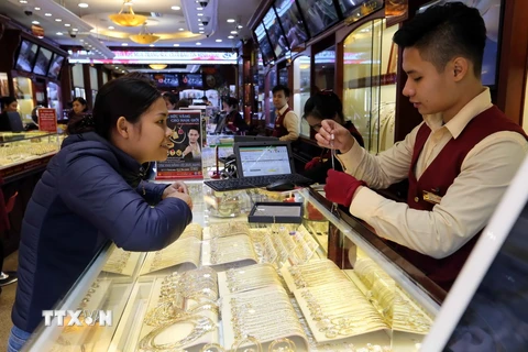 Mua bán vàng tại cửa hàng của Công ty Vàng bạc Bảo Tín Minh Châu, phố Trần Nhân Tông, quận Hai Bà Trưng, Hà Nội. (Ảnh: Trần Việt/TTXVN)
