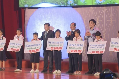 Lãnh đạo tỉnh Bình Dương trao tặng hỗ trợ cho trẻ em có hoàn cảnh khó khăn. (Ảnh: Nguyễn Văn Việt/TTXVN)