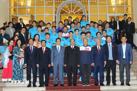 Thủ tướng Nguyễn Xuân Phúc và Phó Thủ tướng Vũ Đức Đam chụp ảnh chung với các cầu thủ Đội tuyển bóng đá U23 Việt Nam. (Ảnh: Doãn Tấn/TTXVN)