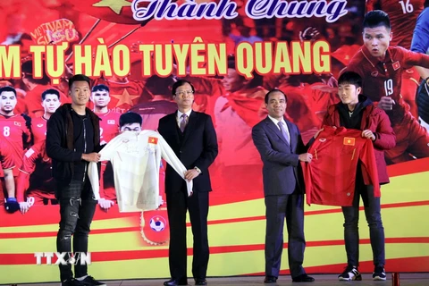 Hai tuyển thủ U23 Lương Xuân Trường, Nguyễn Thành Trung tặng chiếc áo đấu có chữ ký cho lãnh đạo tỉnh Tuyên Quang. (Ảnh: Quang Cường/TTXVN)