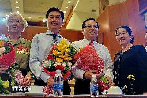 Lãnh đạo Thành phố Hồ Chí Minh tặng hoa và chúc mừng sự đoàn tụ của gia đình bà Diệp Tú Anh (bìa trái), nguyên là chiến sỹ biệt động thành và 2 con trai Diệp Tuấn (thứ 2, từ trái) và Diệp Dũng (giữa) tại buổi họp mặt. (Ảnh: Thế Anh/TTXVN)