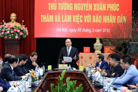Thủ tướng Nguyễn Xuân Phúc tặng quà cho Báo Nhân Dân. (Ảnh: Thống Nhất/TTXVN)