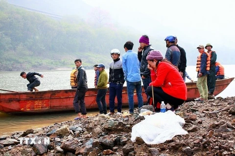 Người thân và những người bạn của các lao động bốc vác bên sông tìm kiếm các nạn nhân. (Ảnh: Phạm Hồng Ninh/TTXVN)