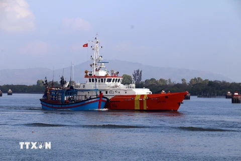 Tàu SAR 413 lai dắt tàu cá QNg 98366 TS về bờ. (Ảnh: Đoàn Mạnh Dương/TTXVN)