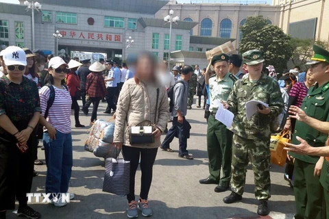 Lực lượng chức năng Việt Nam tiếp nhận chị O nạn nhân bị lừa bán từ phía lực lượng chức năng Trung Quốc. (Ẩnh: Nguyễn Hoàng/TTXVN)