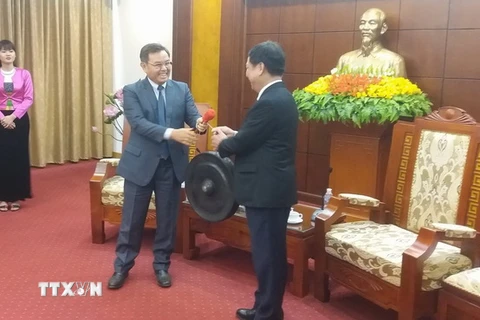 Bí thư Tỉnh ủy Hòa Bình Bùi Văn Tỉnh trao tặng chiếc chiêng Mường, sản phẩm văn hóa đặc sắc của Hòa Bình cho ông Saysomphone Phomvihane. (Ảnh: Nhan Sinh/TTXVN)