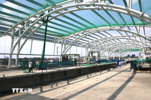 Công nhân lắp đặt lưới an toàn thi công hệ thống mái vòm nhà ga Khu công nghệ cao. (Ảnh: Hoàng Hải/TTXVN)