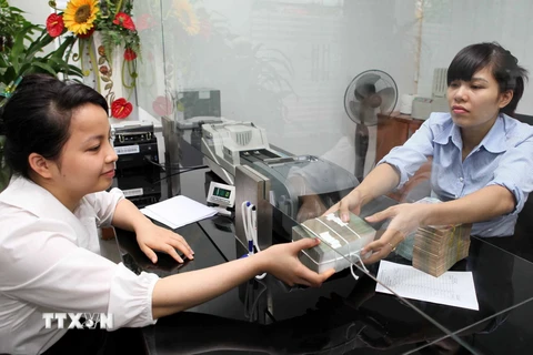 Khách hàng giao dịch tại Hội sở Co-op Bank, phố Nguyễn Thị Định (Hà Nội). (Ảnh: Trần Việt/TTXVN)