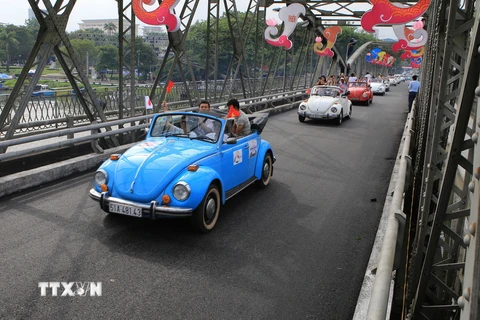 Đoàn xe cổ diễu hành qua cầu Trường Tiền. (Ảnh: Hồ Cầu/TTXVN)