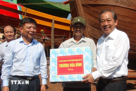 Phó Thủ tướng Trương Hòa Bình tặng quà ngư dân Quảng Bình. (Ảnh: Đức Thọ/TTXVN)