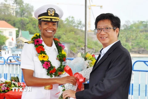 Ông Dương Nam Khánh, Phó Giám đốc phụ trách Sở Ngoại vụ Khánh Hòa (bên phải) tặng hoa cho nữ sỹ quan tàu Bệnh viện USNS Mercy trước giờ rời cảng Nha Trang. (Ảnh: Tiên Minh/TTXVN)