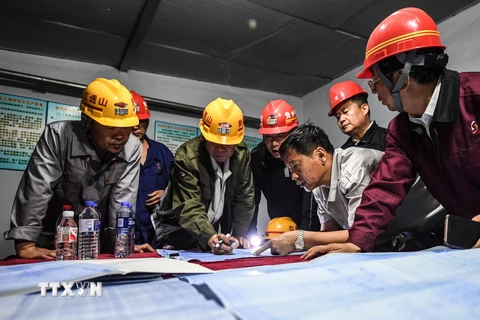 Lực lượng cứu hộ bàn cách thức giải cứu các thợ mỏ bị mắc kẹt sau vụ nổ tại mỏ quặng sắt Bàn Khê ngày 5/6. (Nguồn: THX/TTXVN)