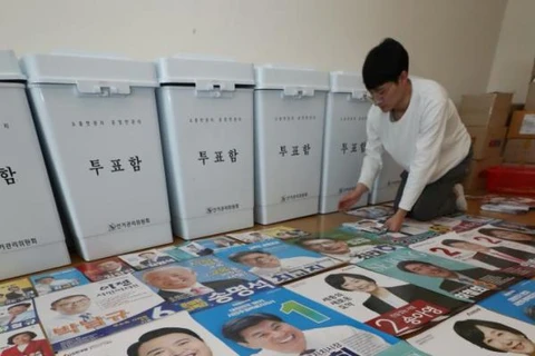 Một nhân viên bầu cử sắp xếp các áp phích ảnh các ứng cử viên cho cuộc bầu cử địa phương ở Sejong, miền Trung Hàn Quốc, ngày 30/5. (Nguồn: Yonhap)