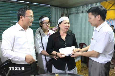 Ông Ngô Văn Quang, Chủ tịch Công đoàn Cục đường thủy nội địa (phải) trao cho gia đình ông Nguyễn Văn Dũng (người đã không may tử nạn trong lúc làm nhiệm vụ) số tiền 50 triệu đồng. (Ảnh: Công Mạo/TTXVN)