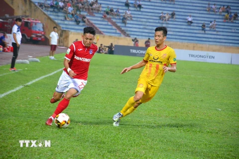 Các cầu thủ Than Quảng Ninh (áo đỏ) đã có thế trận lấn lướt đội chủ nhà Nam Định trên sân vận động Thiên Trường. (Ảnh Công Luật/TTXVN)