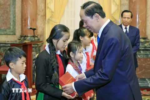 Chủ tịch nước Trần Đại Quang tặng quà cho các trẻ em có hoàn cảnh đặc biệt. (Ảnh: Nhan Sáng/TTXVN)